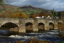 Crickhowell Bridge rebuilt in 1706 and the River Usk in spate and Table Mountain in the background, Brecon Beacon National Park, Breconshire, Wales, November 2018.