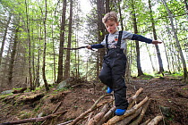 Boy exploring woodland during forest kindergarten session. Aberdeen, Aberdeenshire, Scotland, UK. Editorial use only