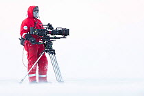 Cameraman Lindsay McCrae with camera on location for BBC Dynasties Penguin programme. Atka Bay, Antarctica. July 2017.
