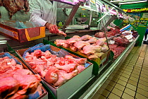 Butcher counter with meat for sale in supermarket, north London, England, UK.