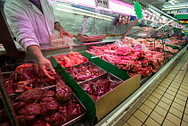 Butcher counter with meat for sale in supermarket, north London, England, UK.
