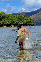 Kanak fisherman carrying his fishing net at the mouth of the Yate River, South Lagoon, Lagoons of New Caledonia: Reef Diversity and Associated Ecosystems UNESCO World Heritage Site. New Caledonia.