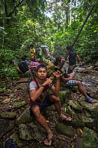 Young Batak man holding a home-made hunting rifle on an almaciga tree (Agathis philippinensis) cone collecting expedition in Cleopatra&#39;s Needle Critical Habitat, Palawan, the Philippines. Septembe...