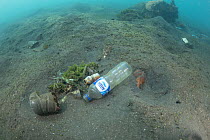 Underwater plastic rubbish such as single use plastic bottles, cups, packaging, labels, waste and woven sacks polluting the seabed, Sulawesi, Indonesia. November 2018.