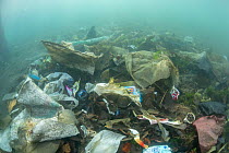 Underwater plastic rubbish such as single use plastic bottles, cups, packaging, labels, waste and woven sacks polluting a coral reef, Sulawesi, Indonesia. November 2018.