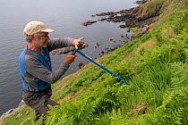 RSPB biologist John Tayton creating artificial Manx shearwater (Puffinus puffinus) nest sites, Garbh Eilean, Shiant Isles, Outer Hebrides, Scotland, UK. June 2018.