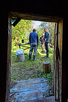 View through door of people talking, whilst on diving expedition. Upper reaches of the Lena River Baikalo-Lensky Reserve, Siberia, Russia. August 2018.
