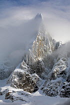 Aiguille du Dru emerging from the clouds in the afternoon, Chamonix area, Haute-Savoie, Mont Blanc area, France, February