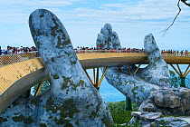 Golden Bridge with giant fiberglass hand appearing to hold up bridge, Sun World Ba Na Hills, Danang, Vietnam.
