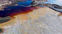 Aerial shot of an artificial lake polluted by extractive pyrite mining, the orange color comes from sulfite and the blue is a reflection of the sky, Minas de Riotinto, Andalusia, Spain, January 2019.