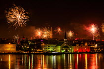 RF - New Years Eve fireworks celebration in Reykjavik, Iceland with lights reflected in the water (This image may be licensed either as rights managed or royalty free.)