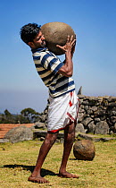 Man of the Toda tribe lifting a heavy stone to show he is ready for marriage. Nilgiri Mountains, Tamil Nadu, India. 2014.