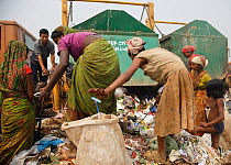 People picking through rubbish from newly arrived skips, on landfill site. Guwahati, Assam, India. 2009.