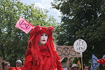 Woman protestor, part of The Red Brigade, at Extinction Rebellion climate change march. Bristol, England, UK. 16 July 2019.
