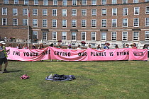 School children holding &#39;The youth are crying our planet is dying&#39; banner at Extinction Rebellion march and rally. Bristol, England, UK. 16 July 2019.