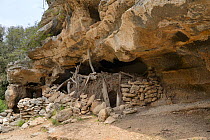 Shepherd&#39;s shelter under limestone rock overhang. Bacu Goloritze ravine, Gennargentu National Park, Baunei, Sardinia, Italy. May 2018.