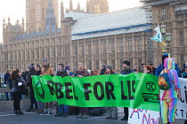 Protestors holding &#39;Rebel for life&#39; banner at Extinction Rebellion climate change demonstration.. Westminster Bridge with Houses of Parliament in background, London, England, UK. 17 November 2...
