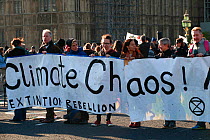 Protestors holding &#39;Climate chaos!&#39; banner at Extinction Rebellion climate change demonstration. London, England, UK. 17 November 2019.