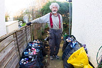 Kevin Whales, man with litter he has picked from street and sorted for recycling. Jaywick, Essex, England, UK.