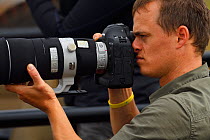 Photographer Bence Mate holding camera, Zimanga Private Nature Reserve, KwaZulu Natal, South Africa