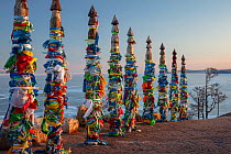 Traditional wooden prayer pillars with flags. Olkhon Island, Buryat Region, Lake Baikal, Siberia, Russia. February 2019.