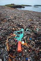 Discarded plastic and nylon rubbish on remote shingle beach. Shetland, Scotland, UK. July 2018.