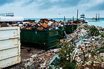 Skips and rubbish on coast of Harbour Island. Waste management can be a challenge on small islands and plastic blows into sea. Bahamas. 2017.
