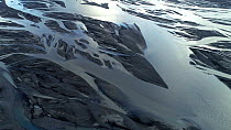 Aerial shot of Kudafljot glacial river flowing over black volcanic soil, Iceland, August 2018.
