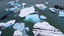 Aerial view of calved ice in the Jokulsarlon meltwater lake beneath Breidamerkurjokull Glacier, Iceland, August 2018.