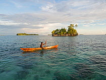 Fisherman in canoe in waters around New Georgia Islands, in evening light. Western Province, Solomon Islands. 2018.