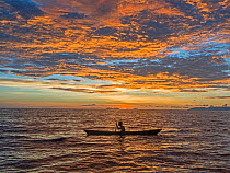Fisherman in dug out canoe at sunset. New Georgia Islands, Western Province, Solomon Islands. 2018.