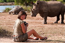 Photographer Ann Toon taking pictures of White rhino (Ceratotherium simum) at Hlane game reserve, Swaziland