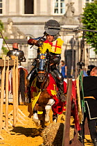 Man dressed as medieval knight riding Pinto stallion, jousting at quintain. Ommegang religious and historical pageant procession, Brussels, Belgium. June 2019.