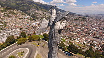 Panning aerial shot looking over Quito, from Panecillo mountain with Statue of the Virgin in foreground to the old historic centre, Ecuador, 2018. (non-ex)