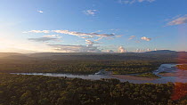 Aerial shot panning over the Rio Napo at sunset, with the Sumaco Volcano and the Cordillera de Galeras in the background, Amazon rainforest, Napo Province, Ecuador, 2017. (non-ex)
