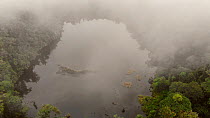 Aerial view of Laguna Wawa Sumaco volcanic crater lake at dawn, with mist blowing through the pristine montane rainforest, Sumaco Volcano, Orellana Province, Ecuador, 2018. (non-ex)