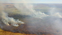 Drone shot of a wild fire in grasslands, with large smoke plumes, Brazil, 2019.