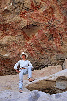 Guide in front of prehistoric rock paintings of Bighron sheep and people. La Pintada cave, San Francisco Sierra, El Vizcaino Biosphere Reserve, Baja California Peninsula, Mexico.