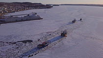 Fishing boats breaking a route through ice so they can leave to fish, the harbour remained frozen unusually late, Lewisporte Bay, Newfoundland and Labrador, Canada, April 2018.