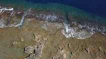 Aerial shot ascending over an eroded coral platform, forming a rugged coast, Aniwa island, Vanuatu, 2018.