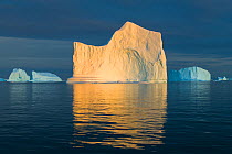Iceberg reflected in Scoresby Sund at sunset. Northwest Fjord, Greenland. August 2019.