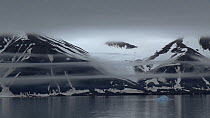 Tracking shot transiting a snowy fjord, with fog lines, Sabine Land, East Spitsbergen, Svalbard, Norway, 2016.