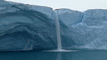 Wide shot of the terminus of Brasvellbreen Glacier, with meltwater waterfall, Svalbard, Norway, 2016.
