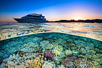 Split level photograph of a liveaboard dive boat (M.Y. Whirlwind), anchored near a coral reef, at sunet. Ras Katy, Sharm El Sheikh, Sinai, Egypt. Red Sea