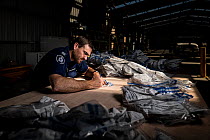Glenn Lineham, a Victoria Wildlife Officer from the Department of Land, Water and Planning (DEWLP), sorts through and documents evidence bags from 406 poisoned Wedge-tailed eagles (Aquila audax) as pa...