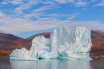 Iceberg and hills in Rode Fjord (Red Fjord), Scoresby Sund, Greenland, August.