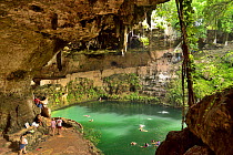 The Zaci cenote with people swimming, in the middle of Valladolid, Yucatan peninsula, Mexico.