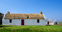 East House / Easthouse Croft, restored traditional white crofter&#39;s house with thatch roof, Papil, West Burra, Shetland Islands, Scotland, UK. June 2018