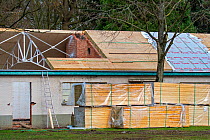 Building fitted with warm pitched roof insulation by installing insulating sandwich panels, Belgium, March 2019.