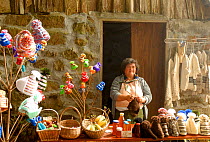 Woman resident of the island Madeira with knitted material and honey for sale, Madiera. October 2006.